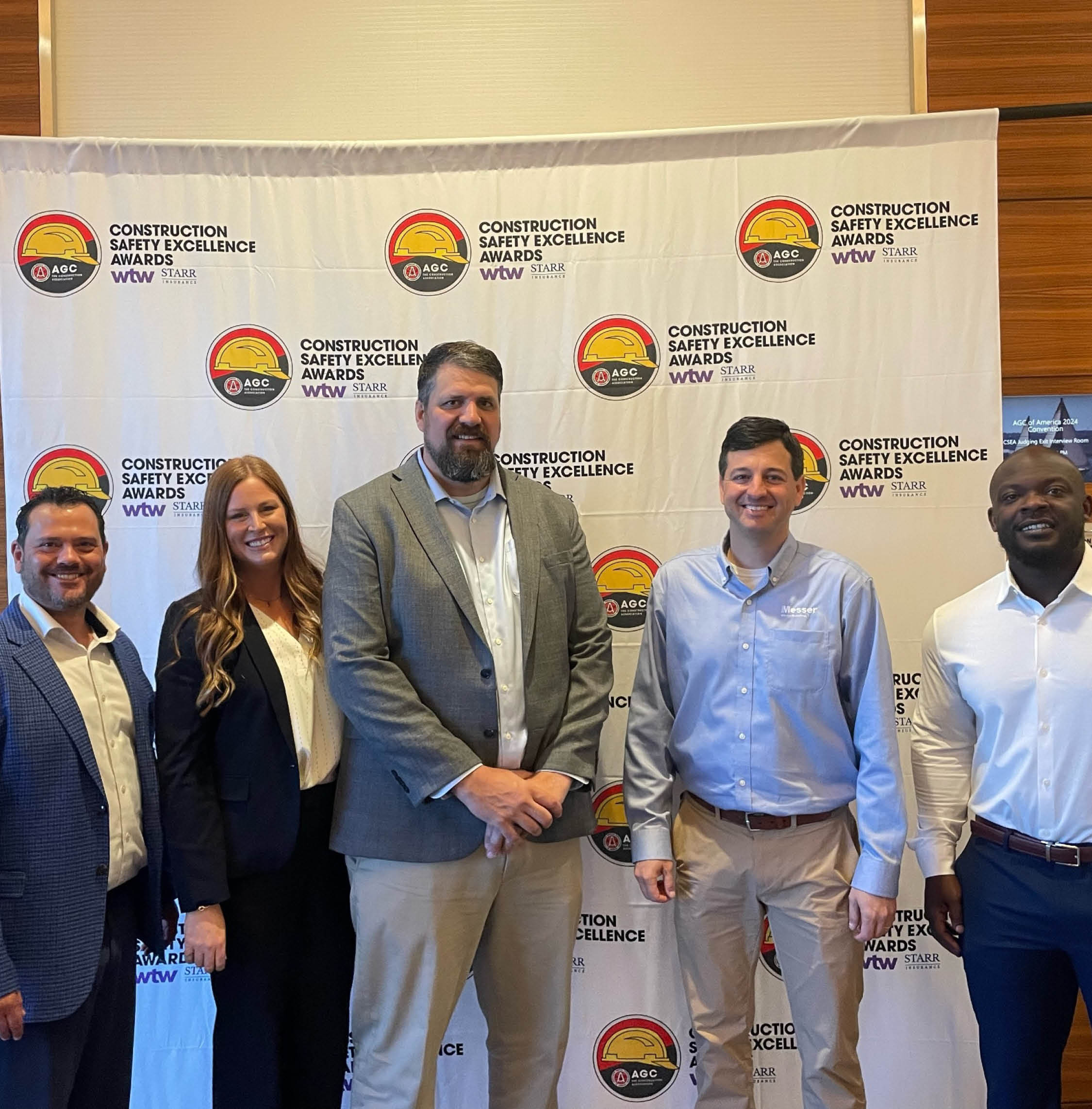 Messer Construction Co. employees standing in front of awards ceremony signage for Construction Safety Excellence